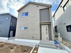 澄み渡る青空の下、洗練された外観の住まいが静かに佇んでいます。落ち着いた色合いの壁と、スマートなデザインの窓が、調和のとれた美しい景観を創り出しています。新しい暮らしの始まりにふさわしい、清々しい雰囲気を感じさせる空間です
