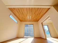 木目の勾配天井が印象的な明るいリビング。
高窓から自然光が降り注ぎ、開放感とあたたかみを両立した空間です。
ナチュラルな色合いで統一された心地よい住まいが、毎日の時間を穏やかに彩ります。